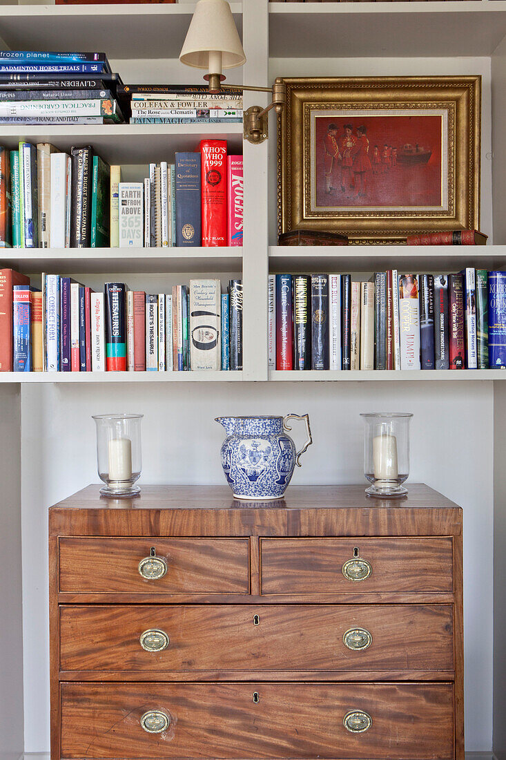 Vergoldetes gerahmtes Bild und Bücher mit Holzkommode in einem Landhaus in Wiltshire England UK