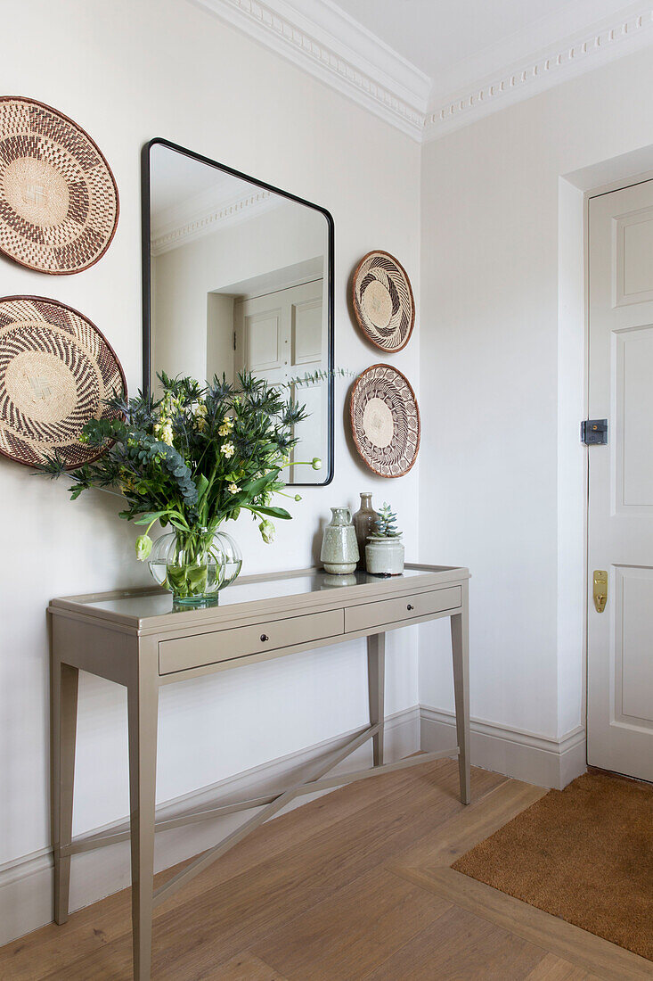 Dekorative Teller und Spiegel mit Blumen an der Eingangstür in einem Londoner Haus UK