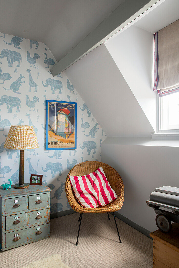 Wicker chair with striped cushion in childs attic bedroom in Cirencester home Gloucestershire UK