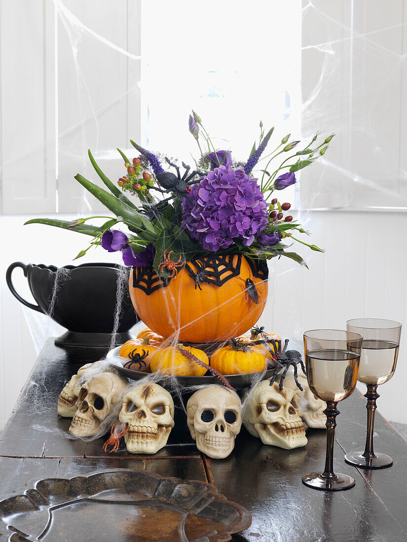Halloween-Mittelstück mit Totenköpfen und Weingläsern auf dem Tisch Brighton, East Sussex UK