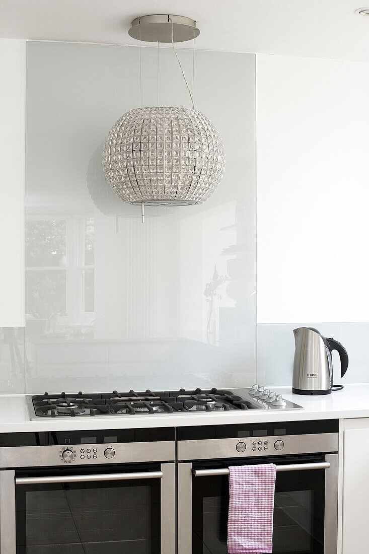 Metallic lampshade above hob unit with kettle in London home