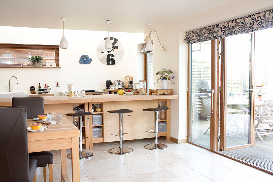 Helle Holzmöbel in der Küche von Isle of White mit Terrassentüren, die zur Terrasse führen
