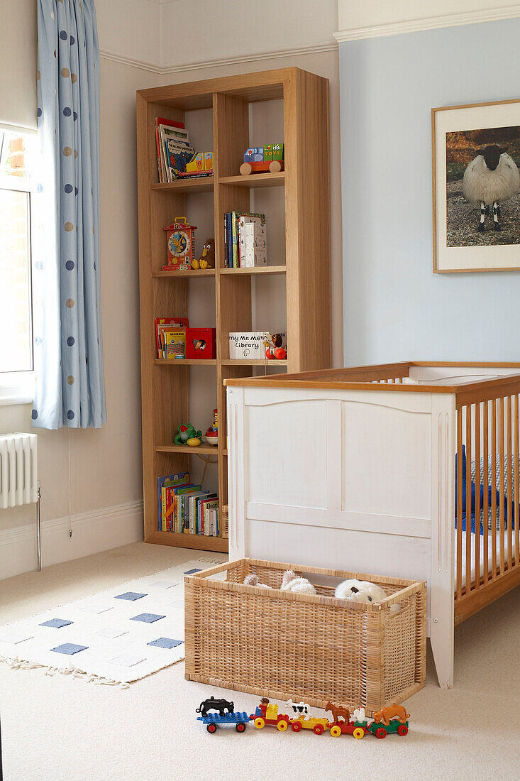 Wooden shelving unit and cot in child's nursery in London home