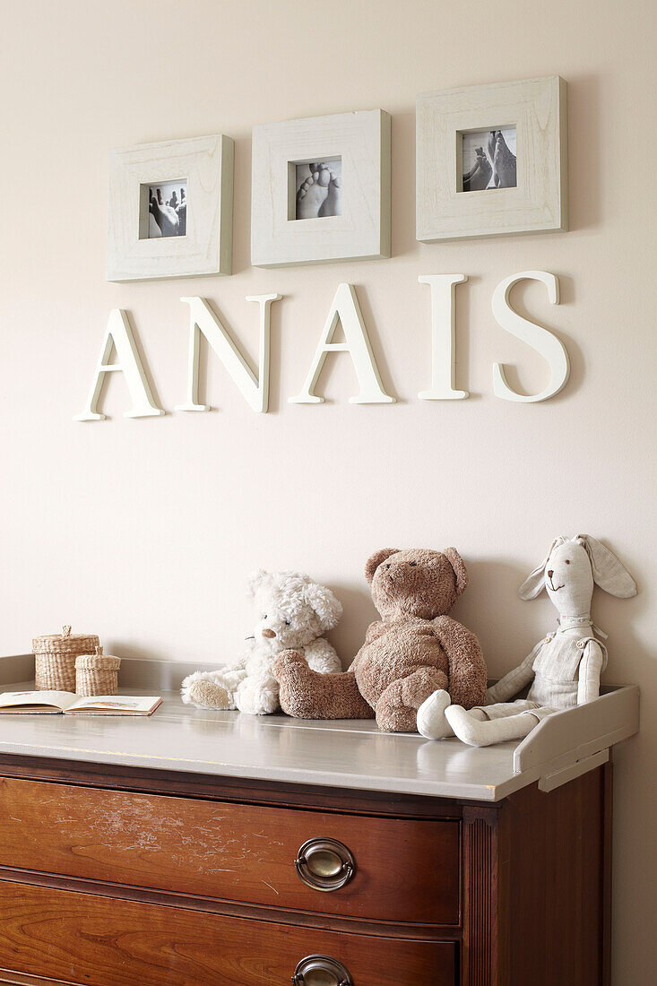 Artwork and lettering with soft toys and changing table in child's nursery of Sydney home Australia