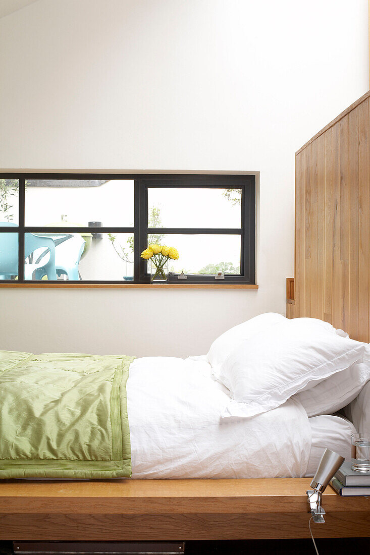 Wooden headboard and green quilt on contemporary platform bed