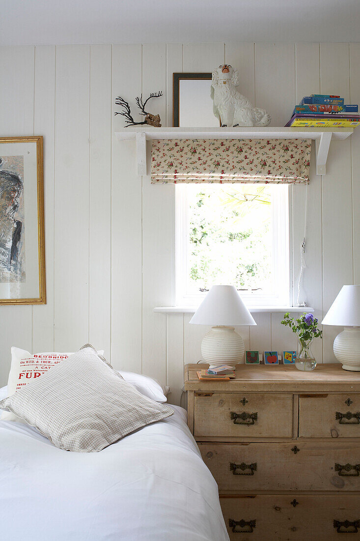 Holzkommode unter dem Fenster eines getäfelten Schlafzimmers in einem Haus auf der Isle of Wight