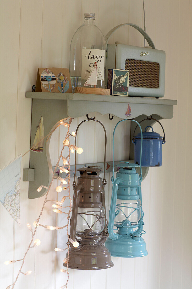 Radio and hurricane lamps on shelf in beach house East Sussex