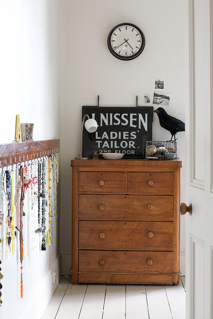 Old fashioned sign and ornaments on wooden chest of drawers