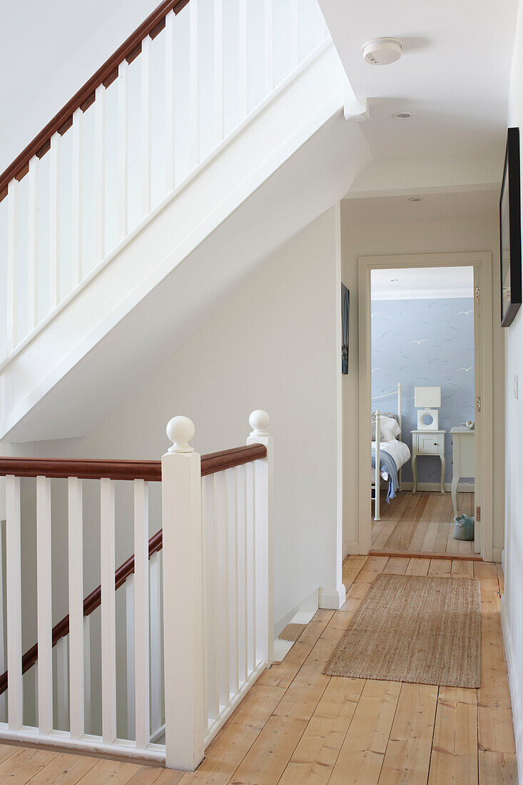 White painted banisters and wooden hallway to bedroom in Bembridge farmhouse, Isle of Wight, England, UK