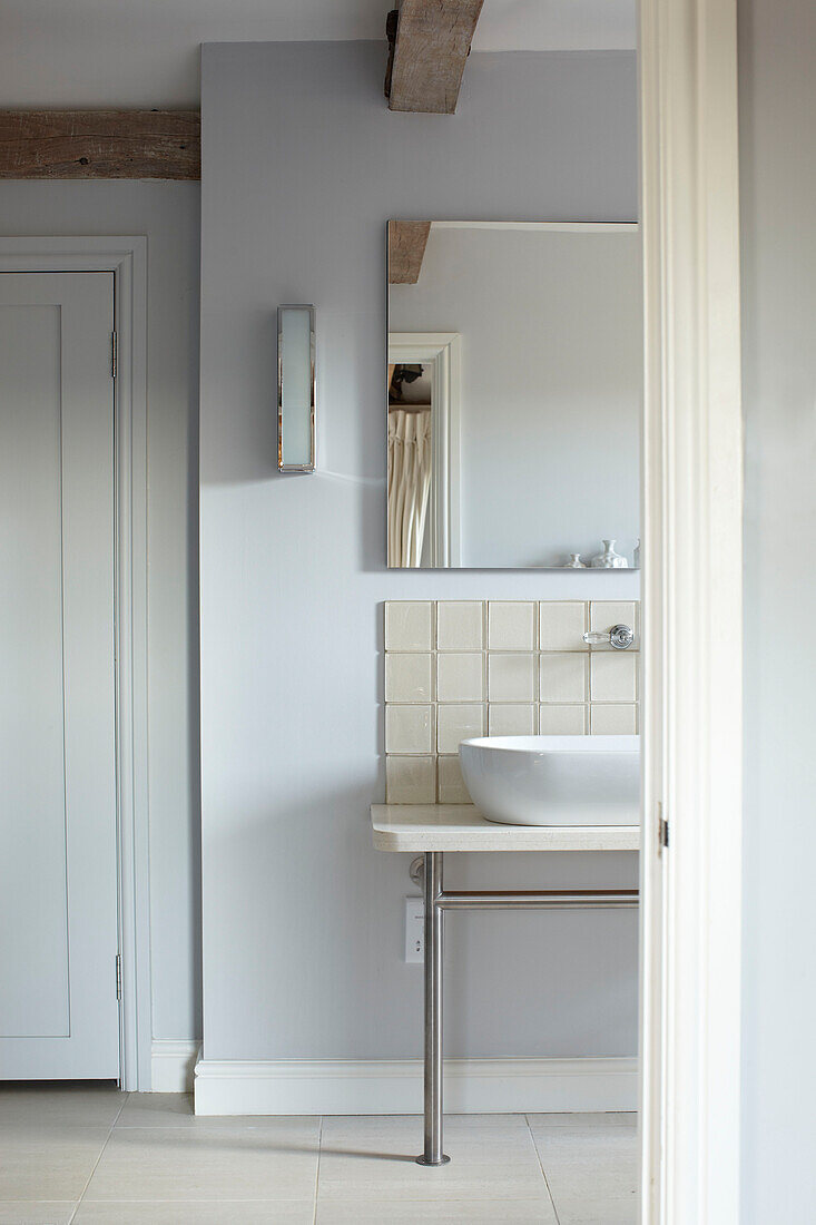 Spiegel über Waschbecken in hellblauem Badezimmer, Haus in Kent, England, UK