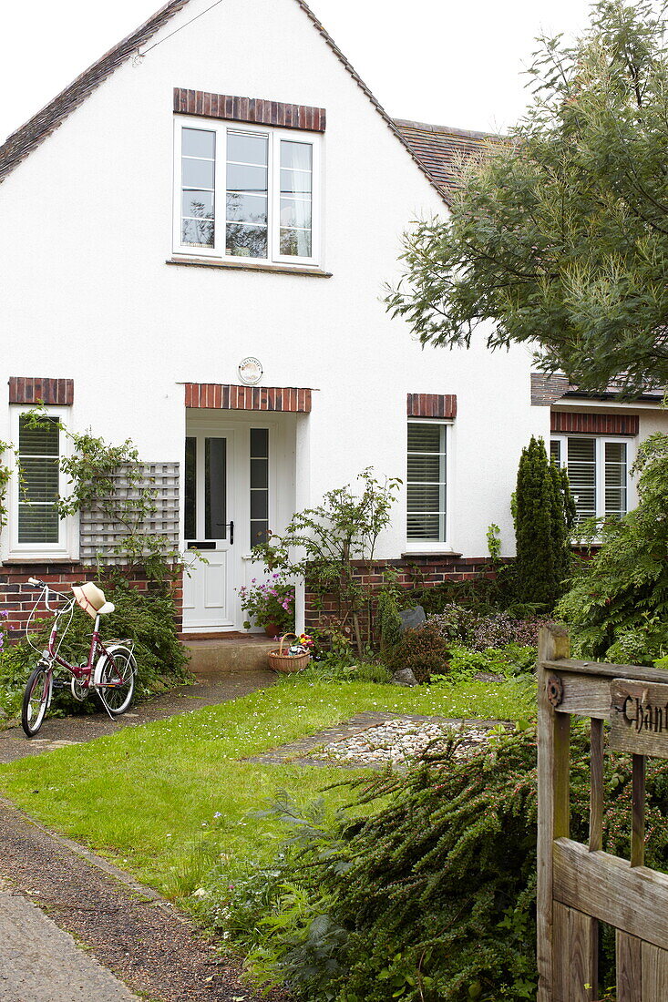 Fahrrad auf dem Fußweg eines weiß getünchten Hauses in Bembridge, Isle of Wight, UK