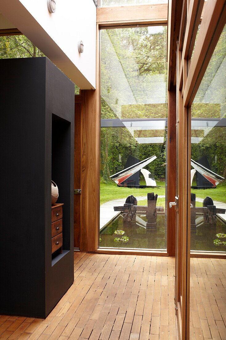 Gläserne Eingangshalle mit Holzfußboden in einem modernen Haus auf der Isle of Wight, Großbritannien