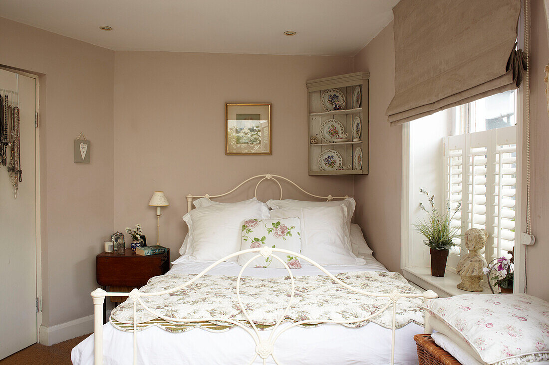 Wandregal über weißem schmiedeeisernem Bett in Doppelhaushälfte UK