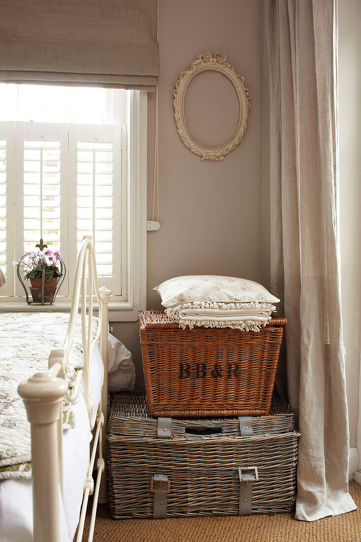 Storage baskets in bedroom detail of semi-detached home UK