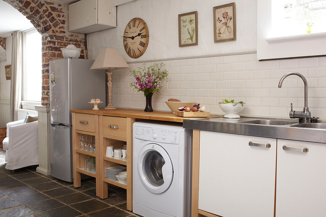Kühlschrank und Waschmaschine in der weiß gefliesten Küche einer Doppelhaushälfte UK