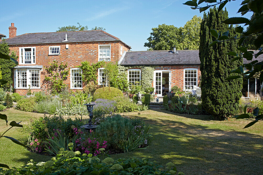 Schattiger Hintergarten eines Einfamilienhauses aus Backstein in Wiltshire, England, Vereinigtes Königreich