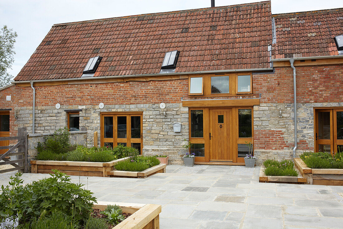 Außenfassade einer umgebauten Scheune in Somerset aus Ziegeln und Stein, England, UK