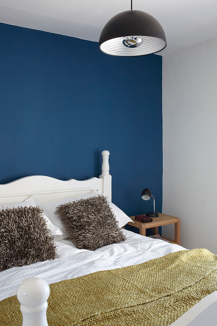 Senfgelbe Decke und blaue Wand in einem modernen Schlafzimmer in Weymouth, Dorset, Vereinigtes Königreich