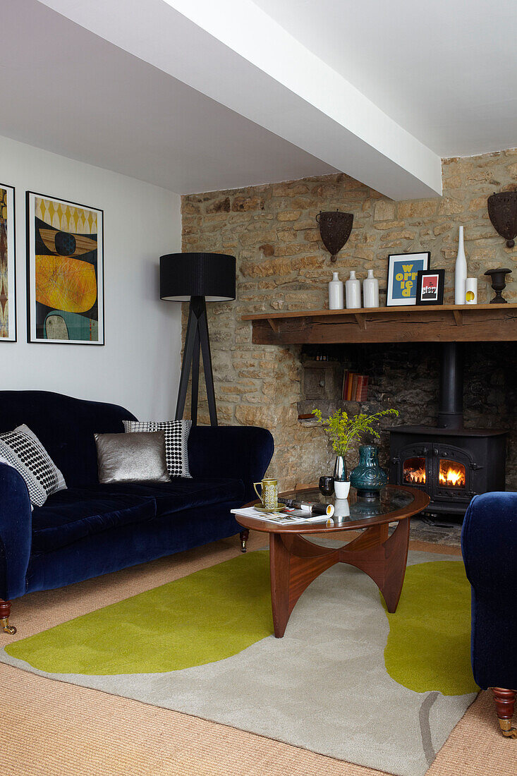 Blue velvet sofas at fireside in Coombe cottage, England, UK