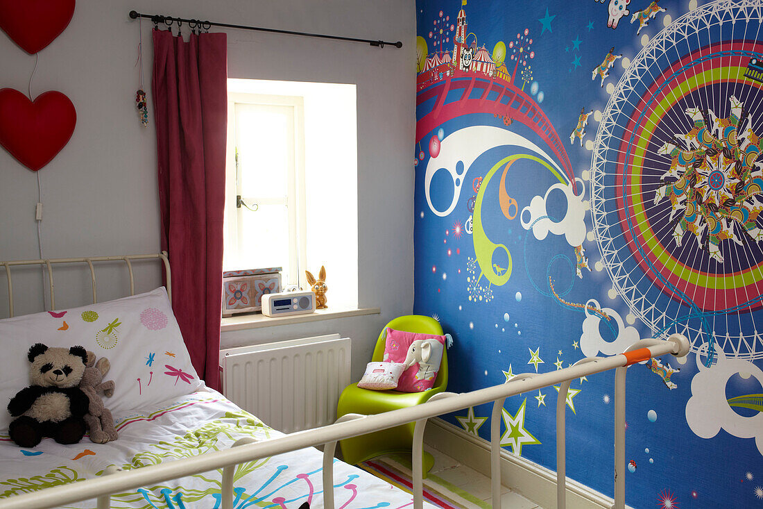 Farbenfrohe Wanddekoration im Mädchenzimmer eines Cottage in Coombe, UK