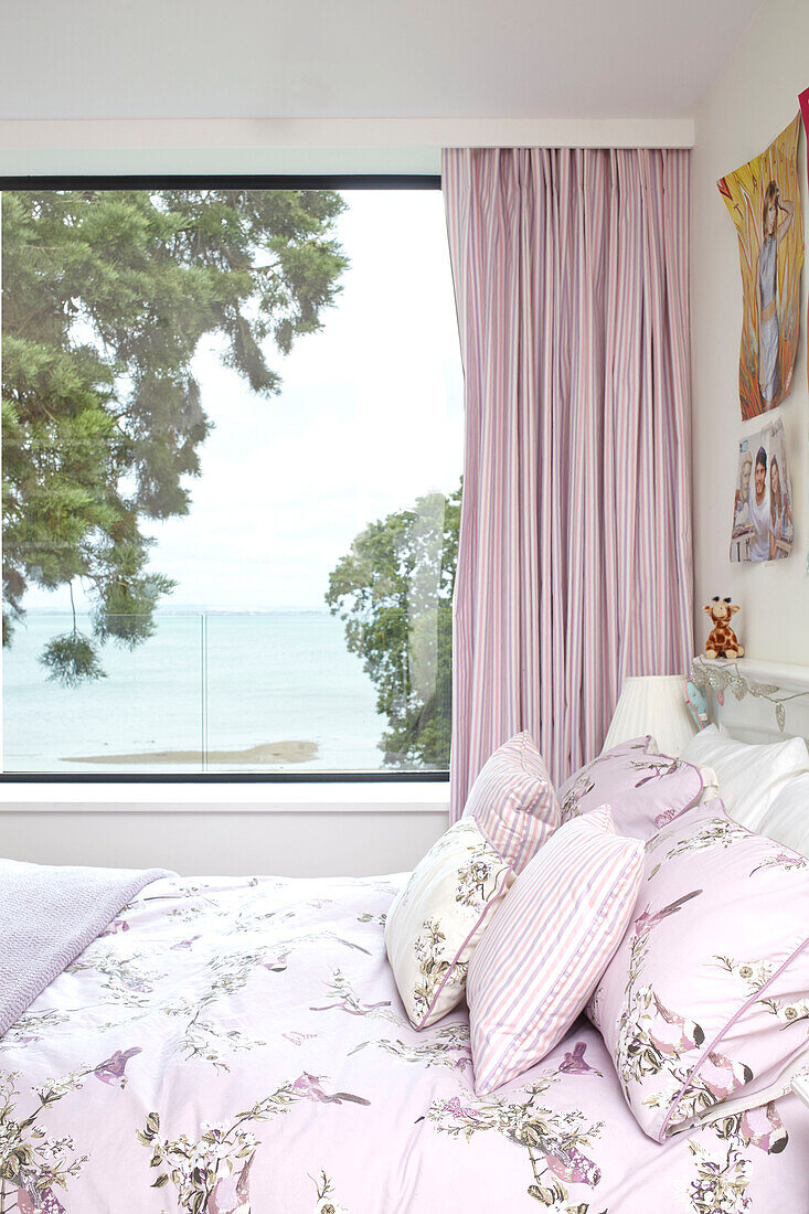 Pink curtains at window with floral duvet in bedroom of Isle of Wight home UK