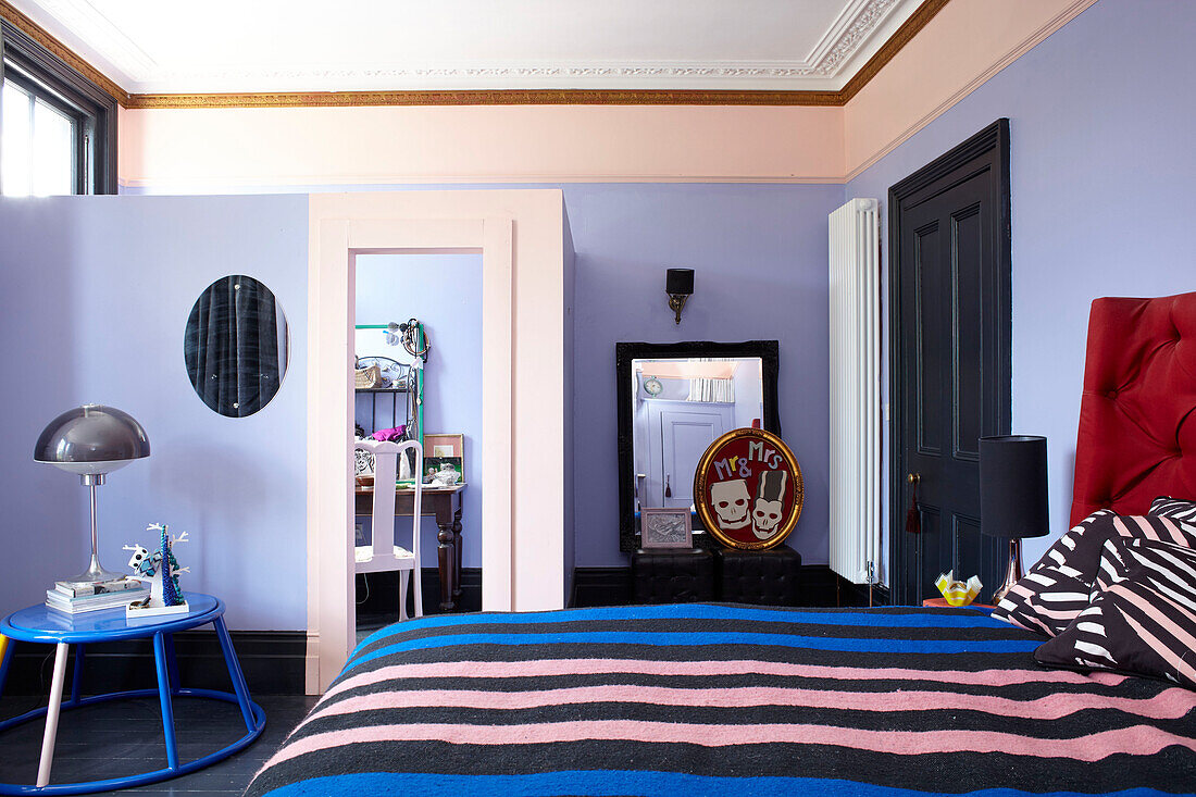 Schlafzimmer mit fliederfarbener Trennwand in einem Stadthaus in Hastings, East Sussex, England UK
