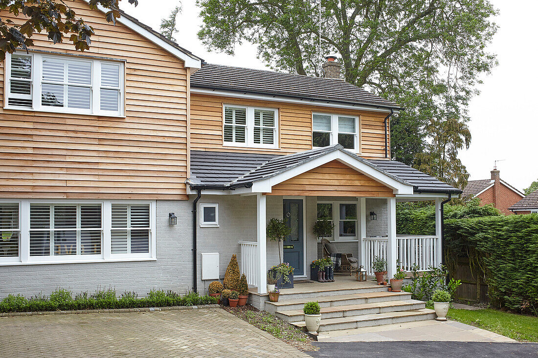 Colonial style wood cladding and open veranda of Buckinghamshire home UK