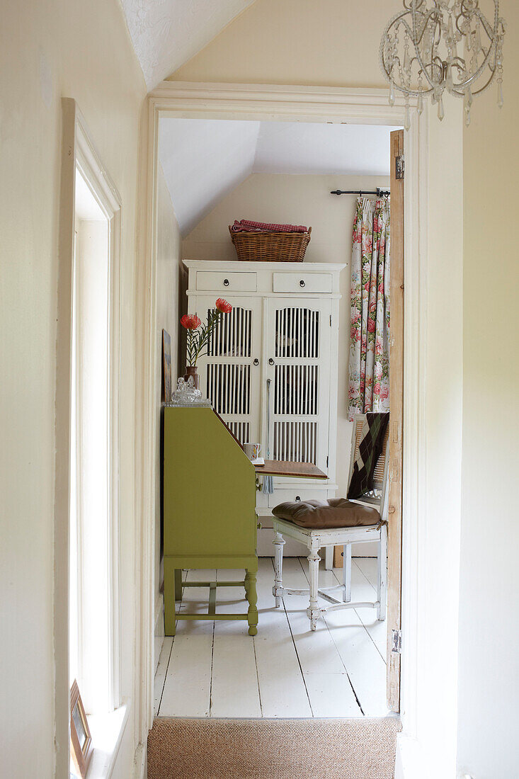 Blick durch die Tür auf den lindgrünen Schreibtisch in einem Haus in East Cowes, Isle of Wight, UK