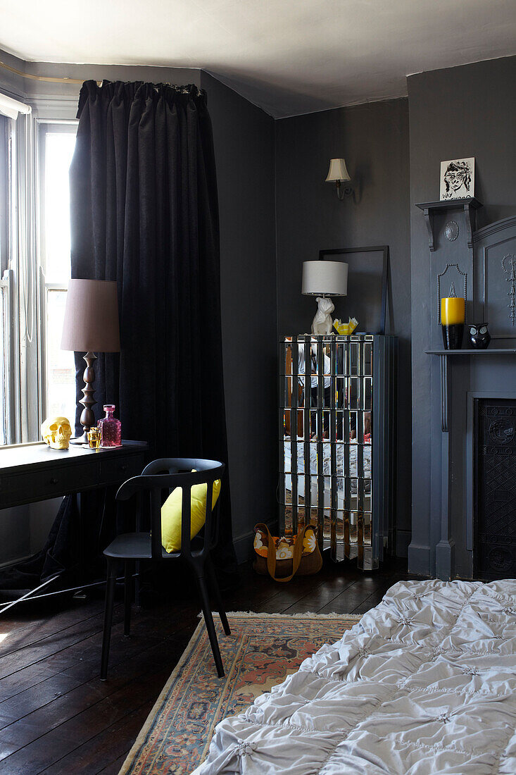 Schwarzer Stuhl am Fenster mit Spiegelschrank in einem Londoner Schlafzimmer, England, UK
