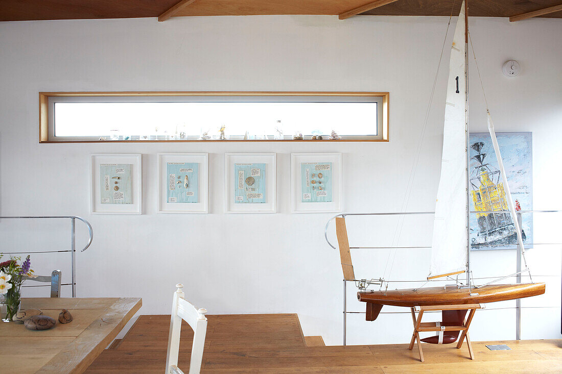Rectangular window above artwork with model boat in Bembridge houseboat Isle of Wight, UK