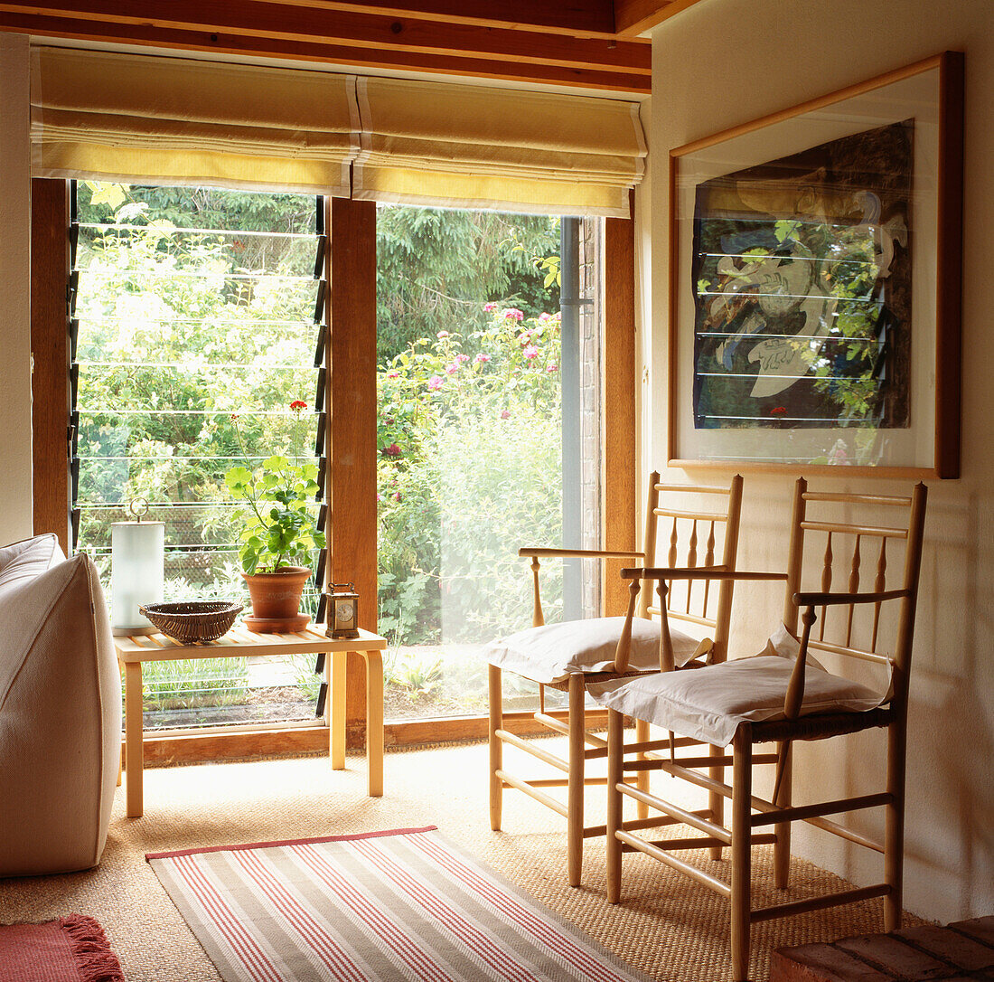 Modernes Wohnzimmer im Landhausstil mit Schnitzerstühlen im Shaker-Stil und Lattenfenster mit Blick in den Garten