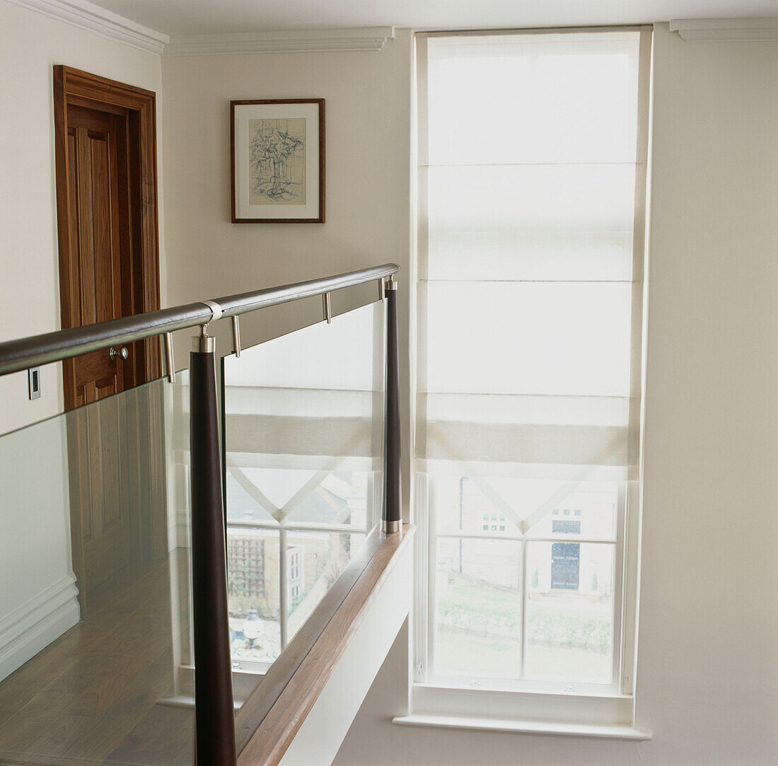 Long window with blind on landing with glass panelled balustrade