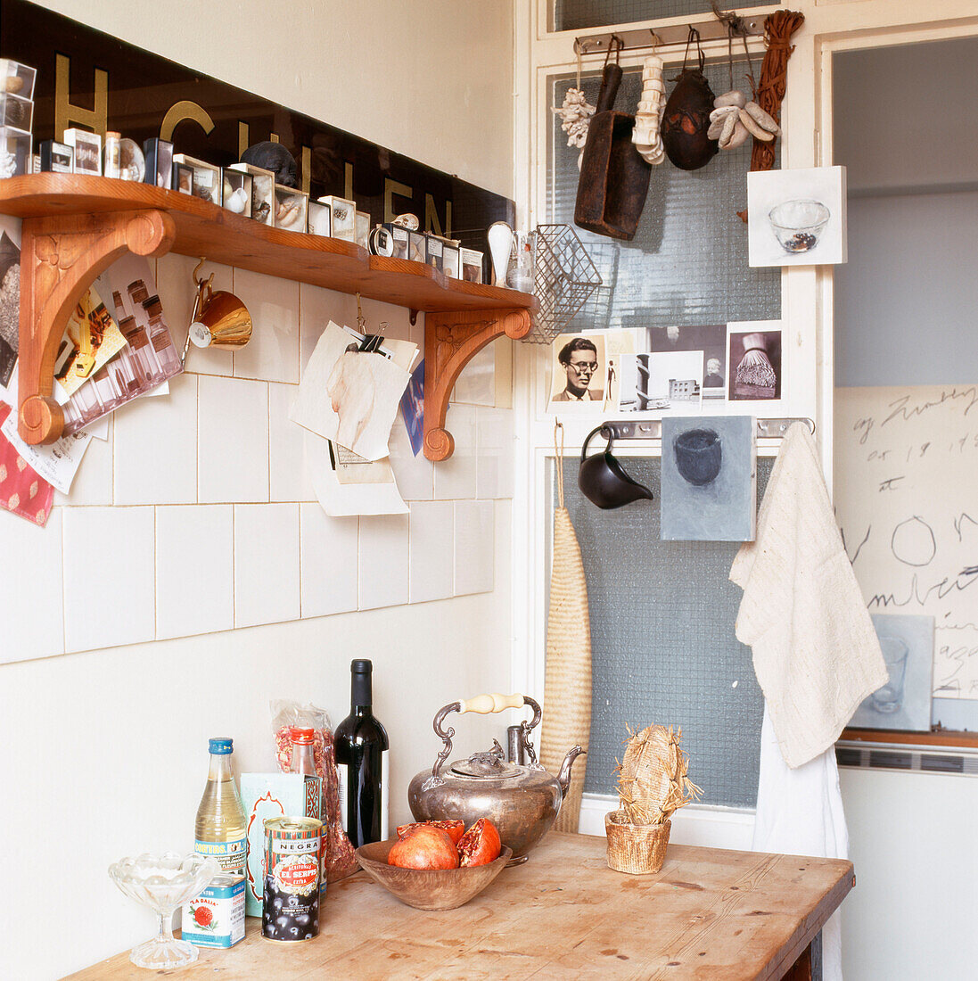 Küchendetail mit Postkarten und Vintage Objekten über einem Holztisch