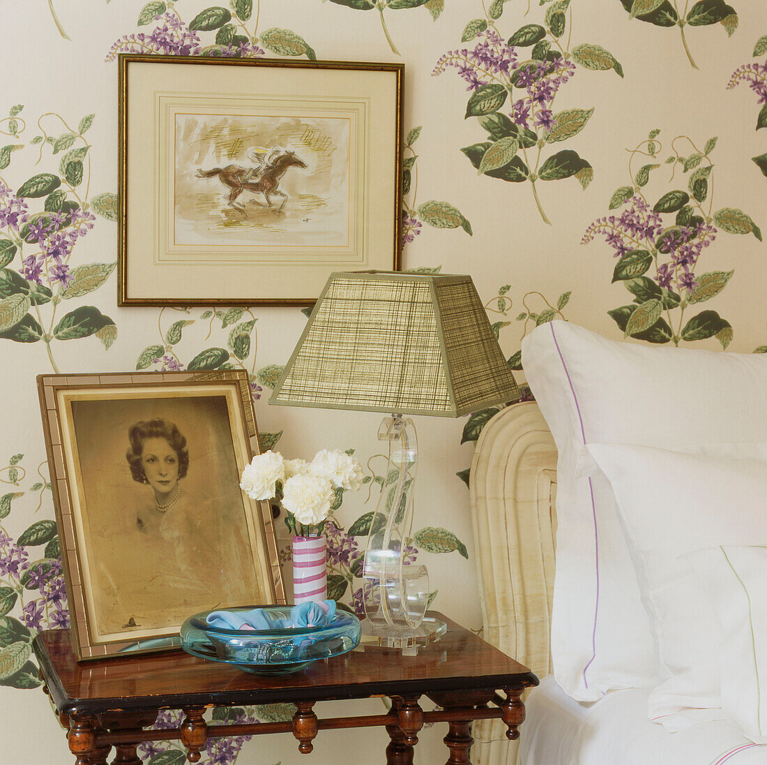 Bedroom detail with pretty floral pattern wallpaper and bedside table