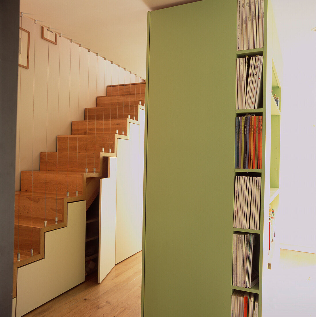 Stauraum unter der Treppe und hinter viereckigem, blassgrünem MDF-Paneel
