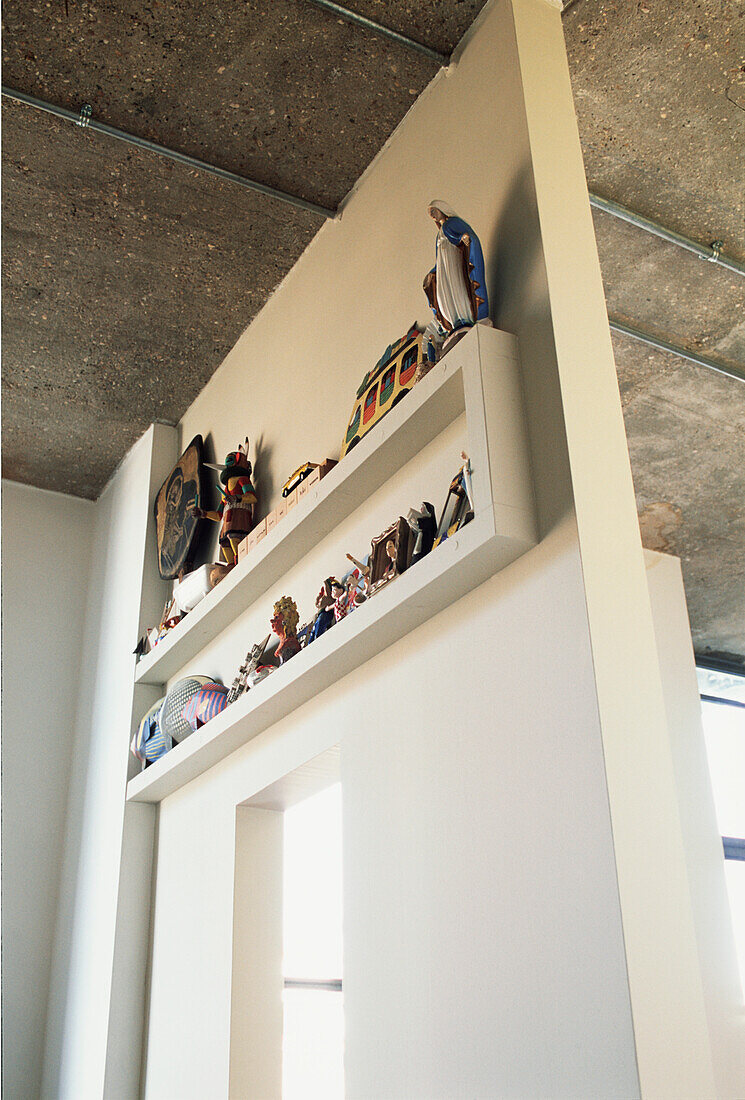 Wandpräsentation von Kitschobjekten auf einem Raumteiler