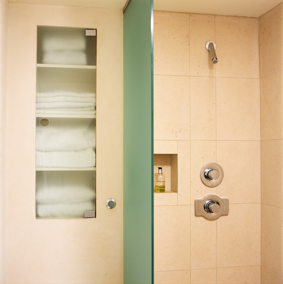 Geflieste Power-Dusche mit Handtüchern und Sichtschutz
