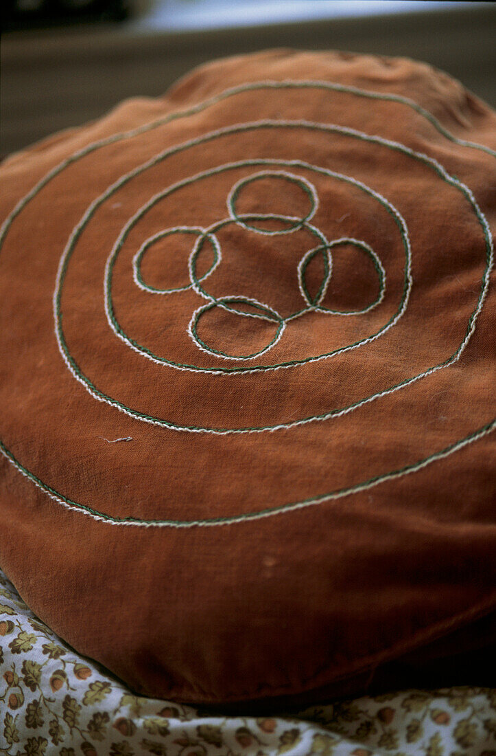 Beige round velvet cushion with simple motif design