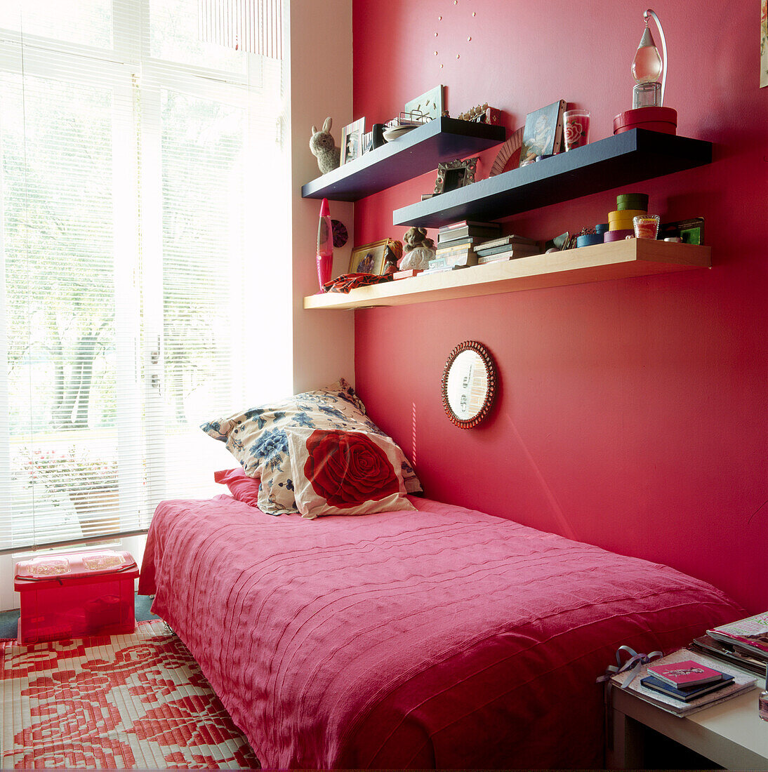 Nahaufnahme eines roten Einzelzimmers für Teenager mit Flügelfenster