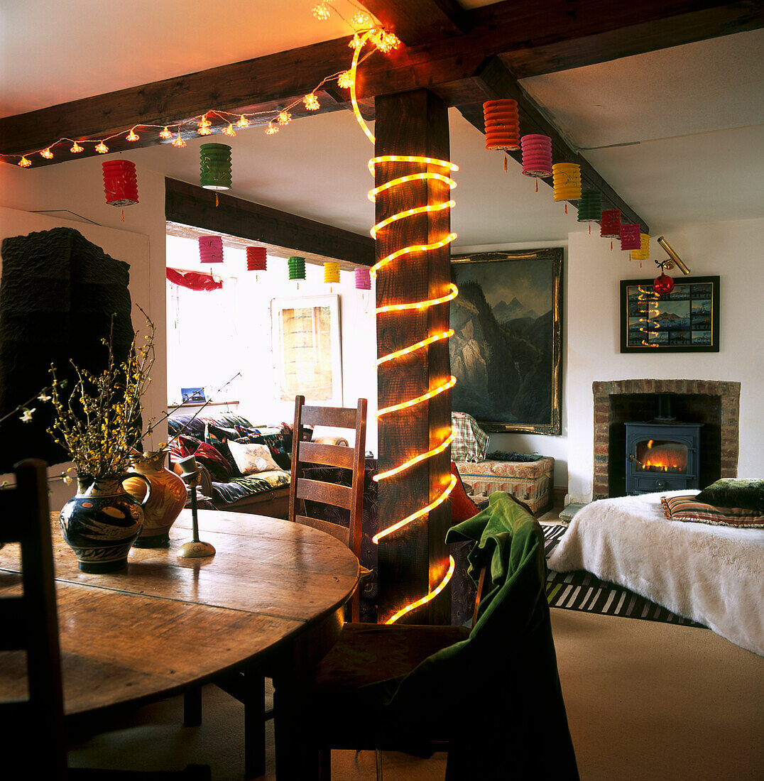 Fairy lights and paper lanterns adorn country cottage living room and dining area