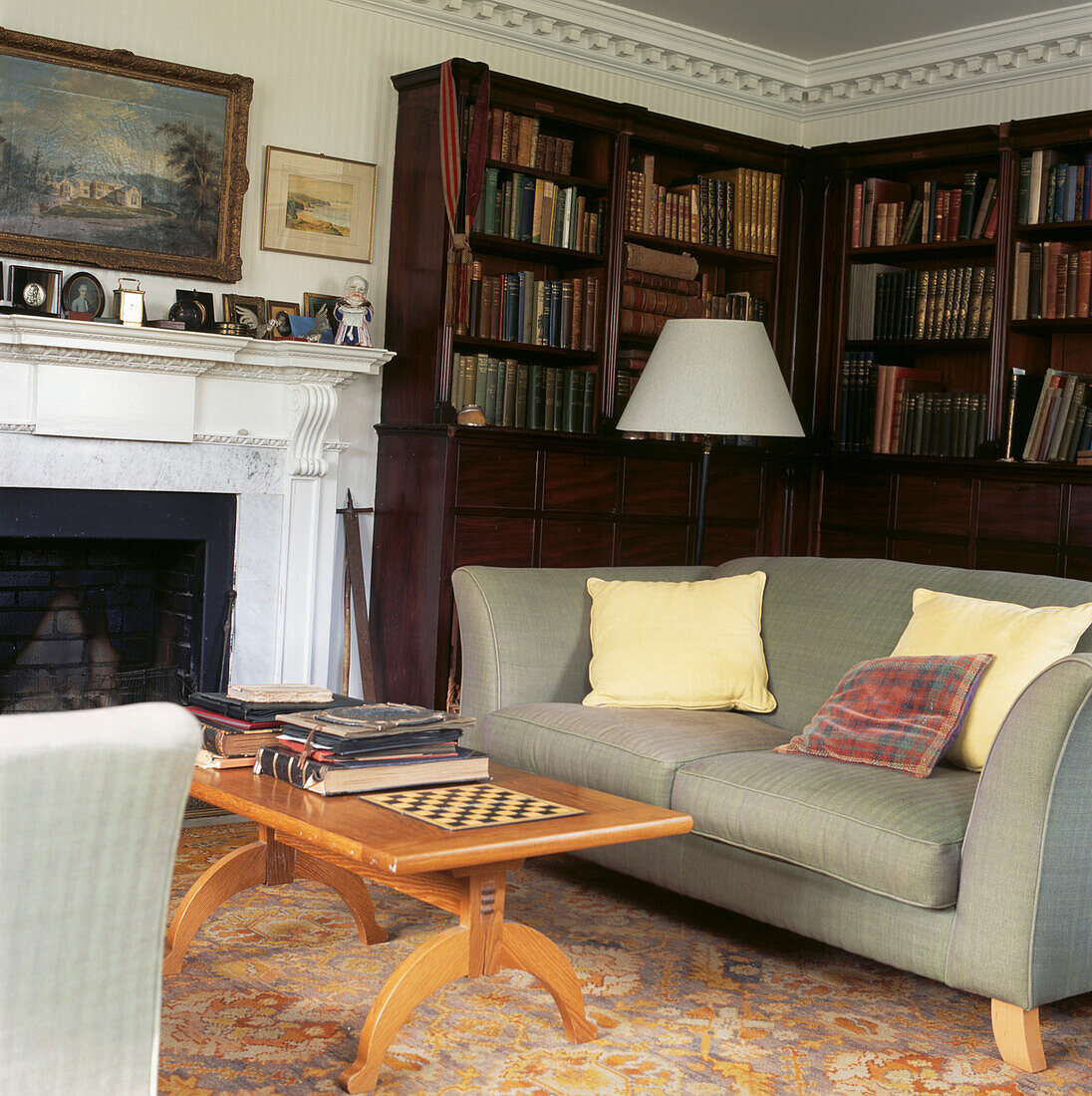 Graue Sofas vor dem Kamin im Familienwohnzimmer mit Mahagoni-Bücherregal