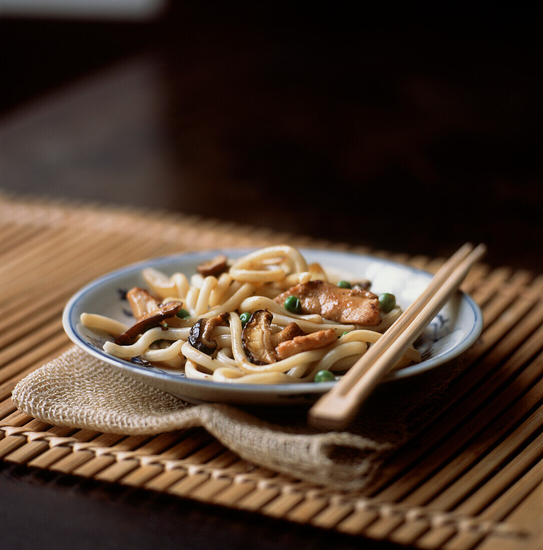 Udon-Nudelgericht mit Ingwer-Huhn, Shiitake-Pilzen und Erbsen