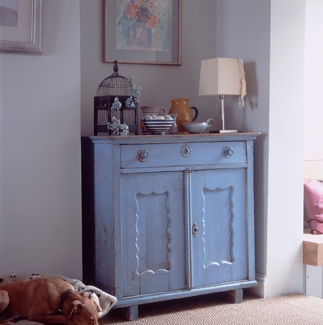 Stilleben von Gegenständen auf einem alten, blau gestrichenen Holzschrank im Wohnzimmer