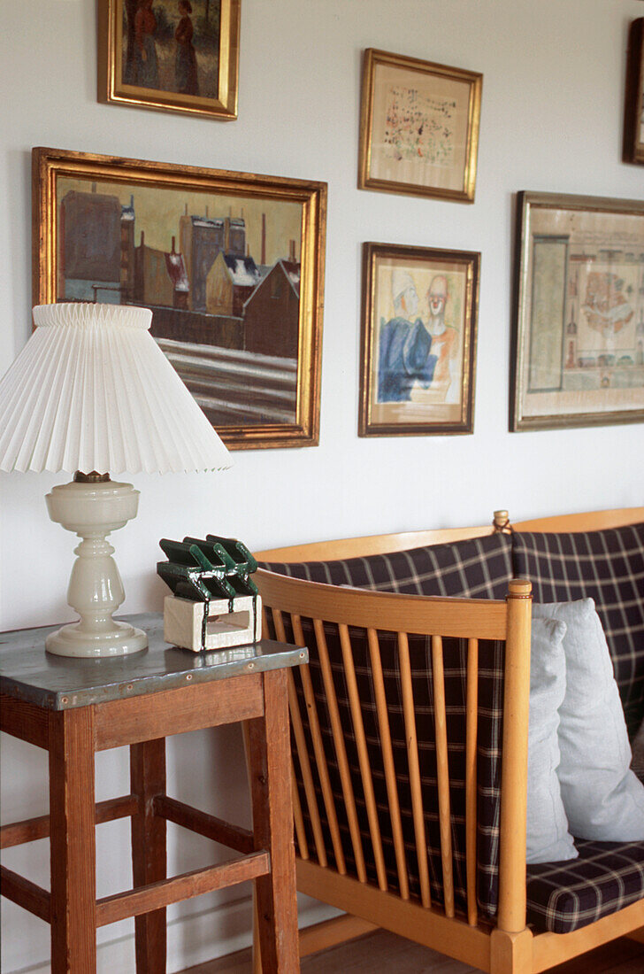 Modernes weißes Wohnzimmer im Landhausstil mit holzgerahmten Sofas, Beistelltisch mit Metallplatte und Bildern an den Wänden