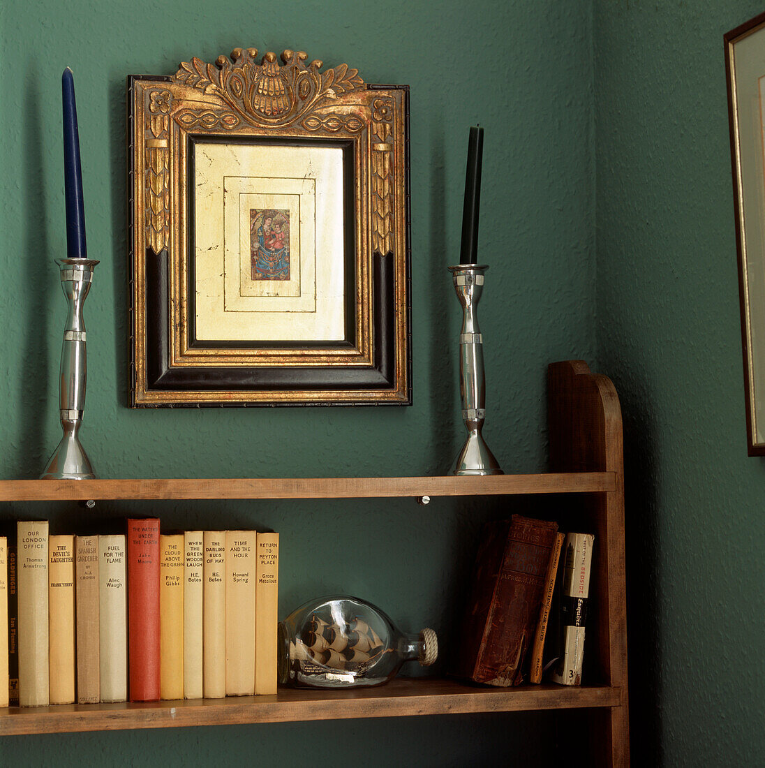 Detail of corner of room with vintage wooden bookshelves and ornaments displayed 