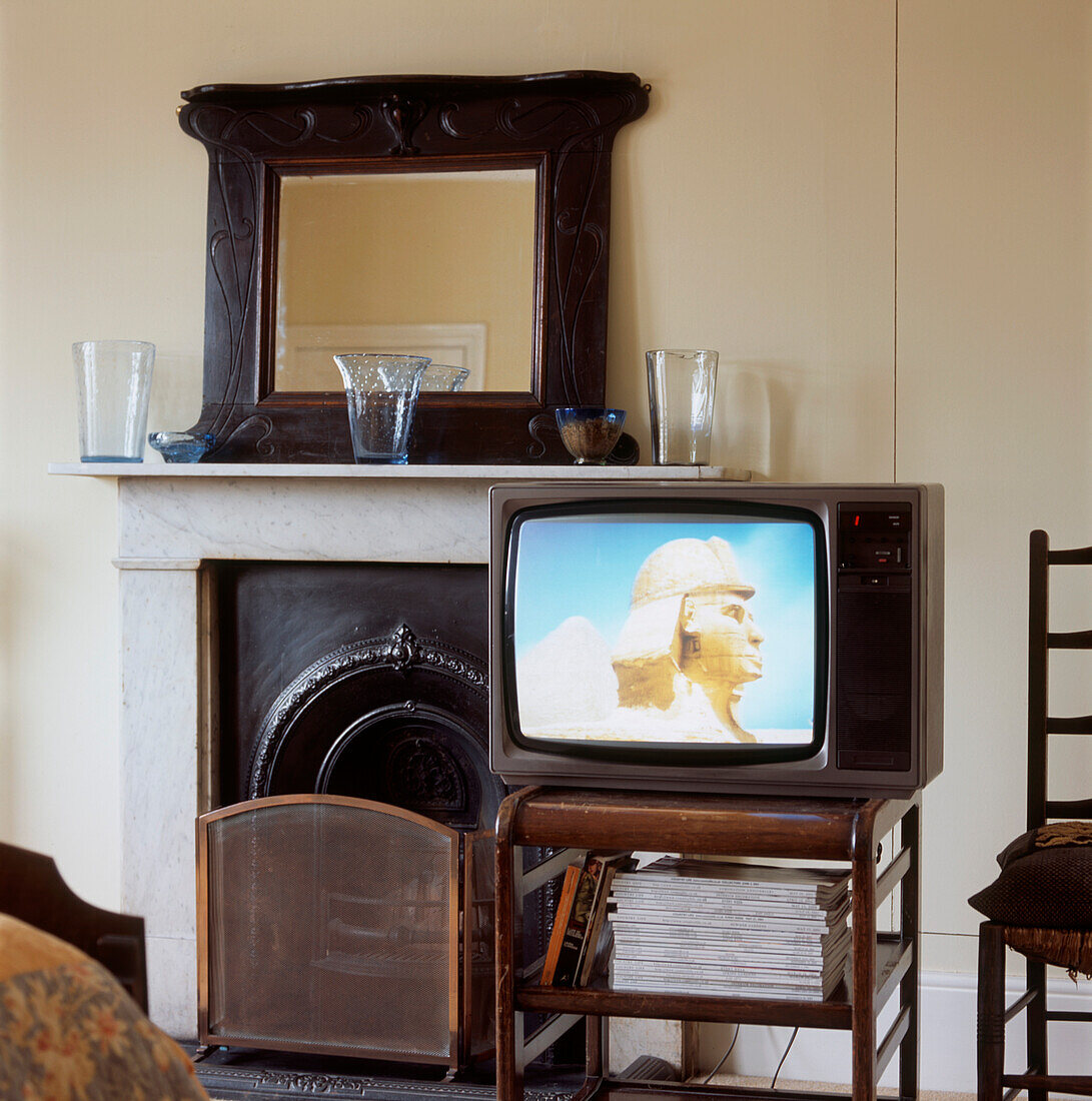 Schlafzimmer mit viktorianischem Kamin und Fernseher auf dem Beistelltisch