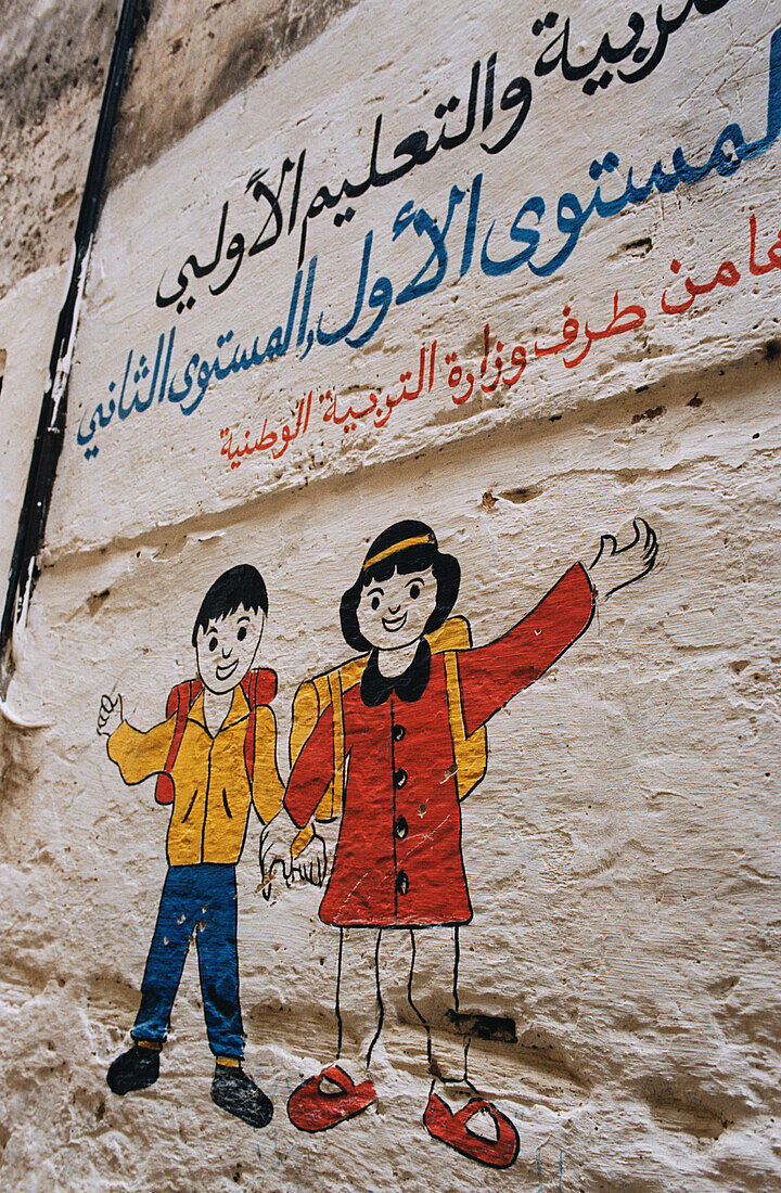 Wall painting of waving children in the medina in Fez Morocco