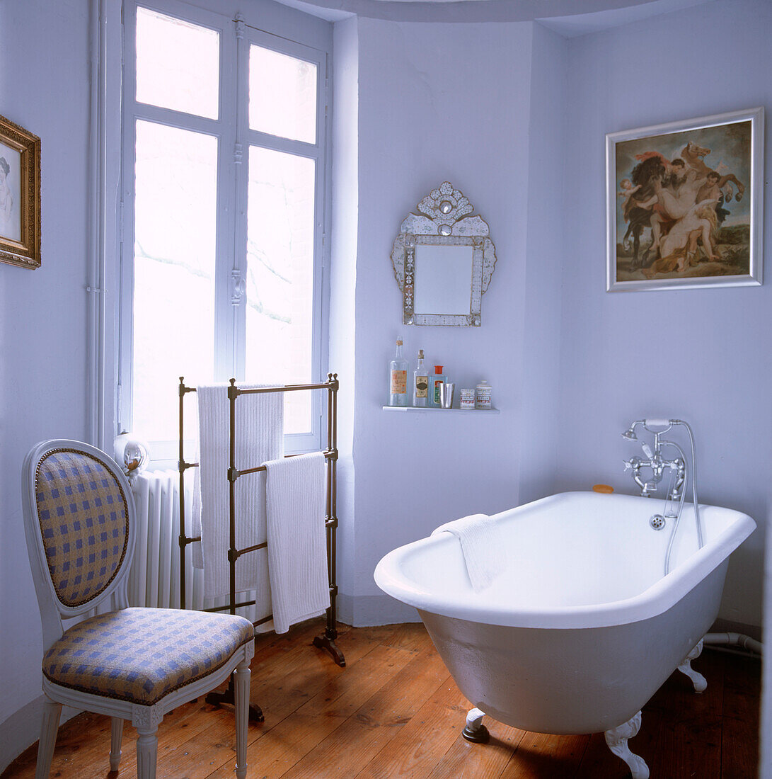 Badewanne mit Rolltop in einem weiß gestrichenen Badezimmer