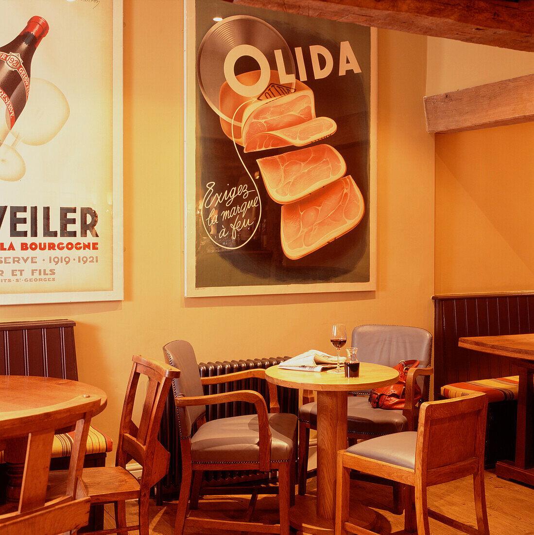 Cafe-Bar mit Tischen und Stühlen und großen Grafikpostern an der Wand
