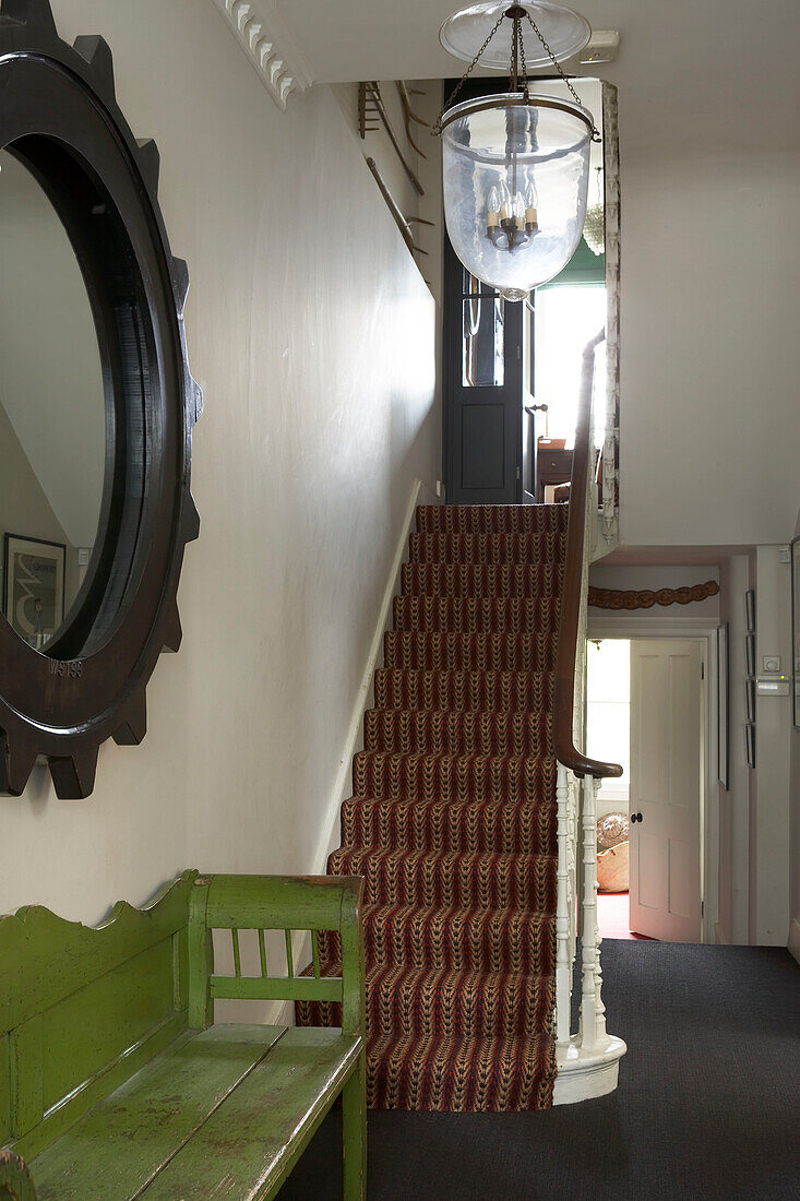 Hall stairs and landing with sisal carpet and weathered green bench